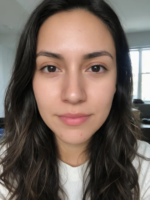 The woman's same selfie with Beautify Me at Light: skin and under-eyes retouched; hair, clothes and background unchanged
